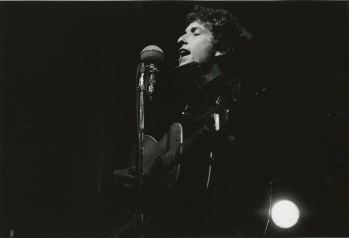 Photograph of a man singing into a microphone
